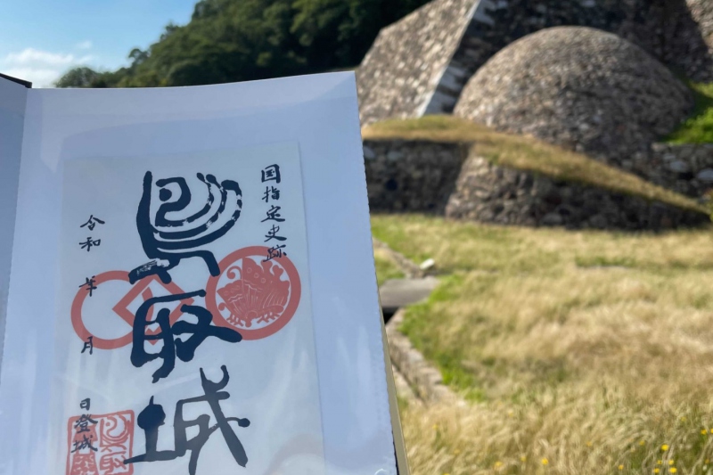 鳥取城の「御城印」～鳥取城のシンボル丸い石垣である「天球丸 巻石垣」を背景に～